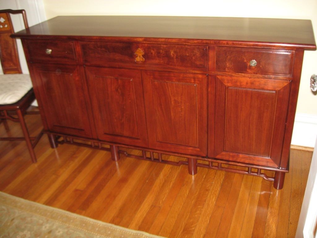 Dark wood cabinet with drawers and doors, on hardwood floor.