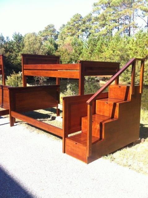 Wooden bunk bed with attached stairs outdoors.