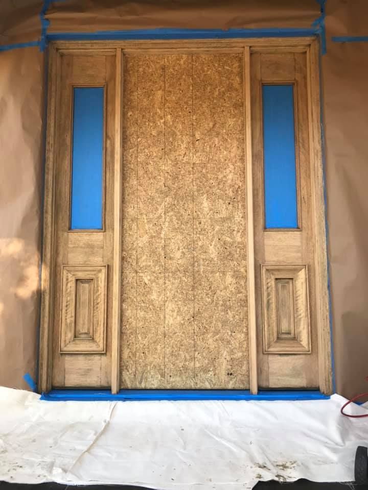 Wooden door frame covered with masking and protective paper for painting.
