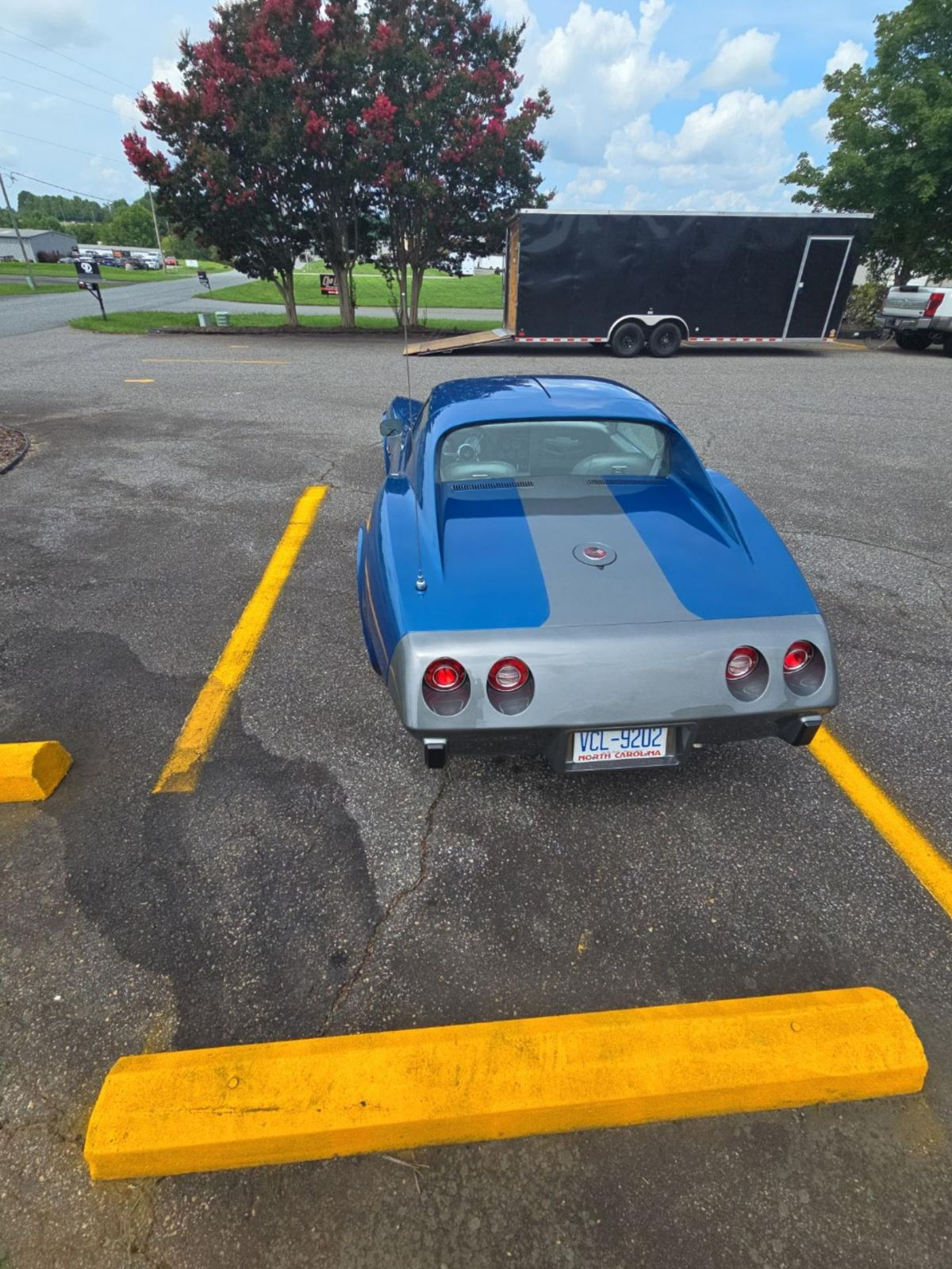 A blue and gray corvette is parked in a parking lot