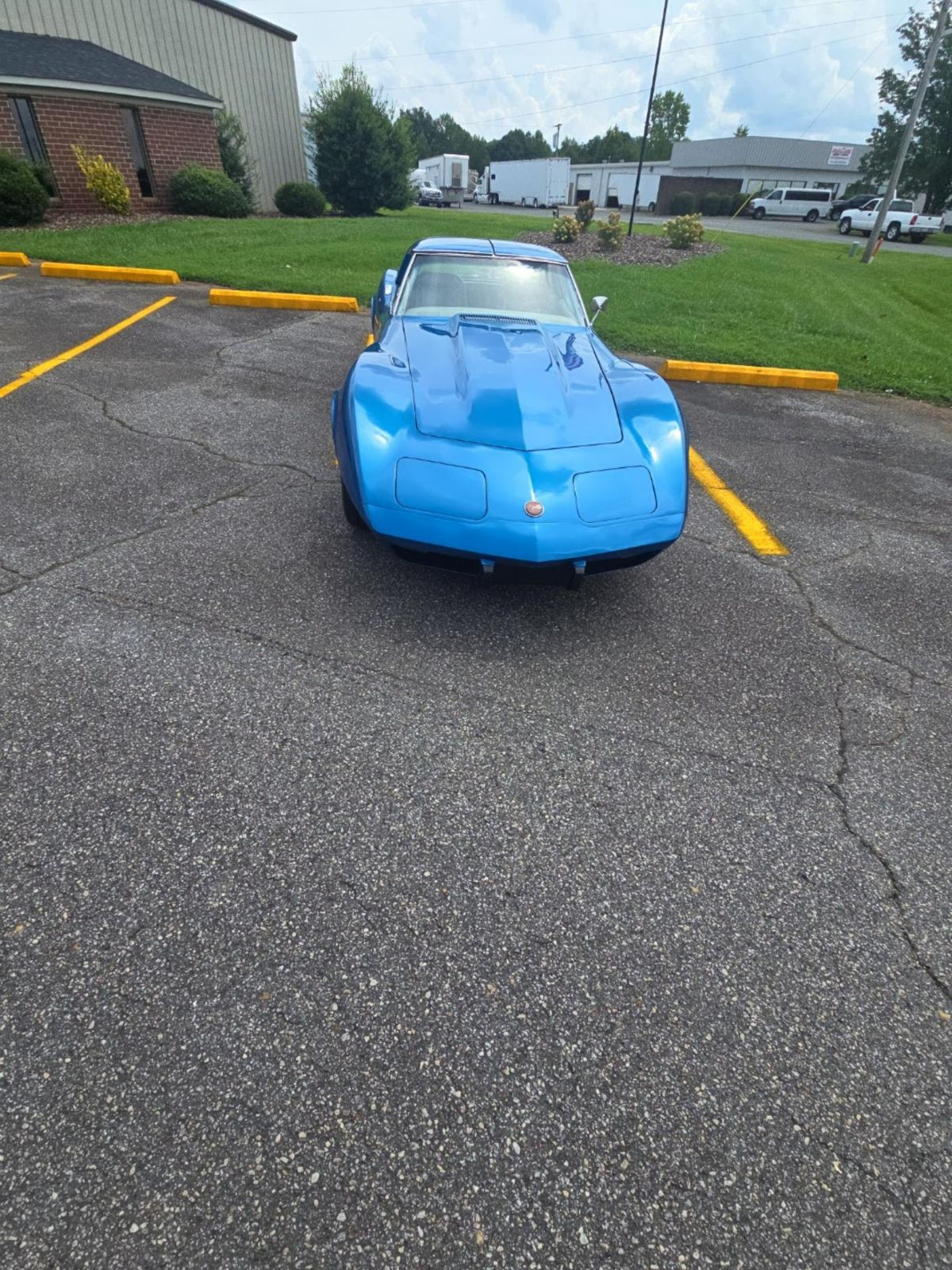 A blue sports car is parked in a parking lot.