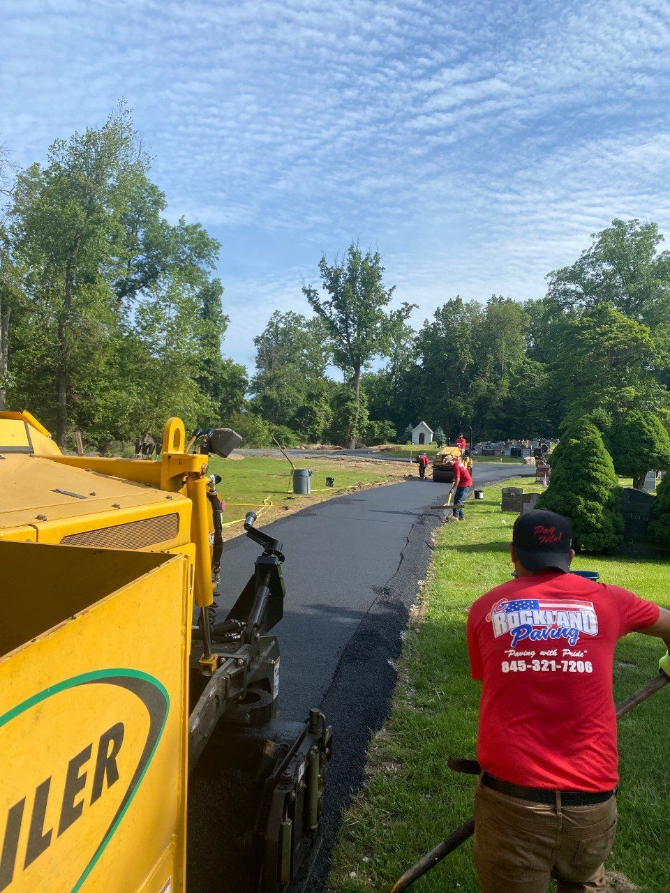 A man in a red shirt is standing next to a yellow truck that says miller