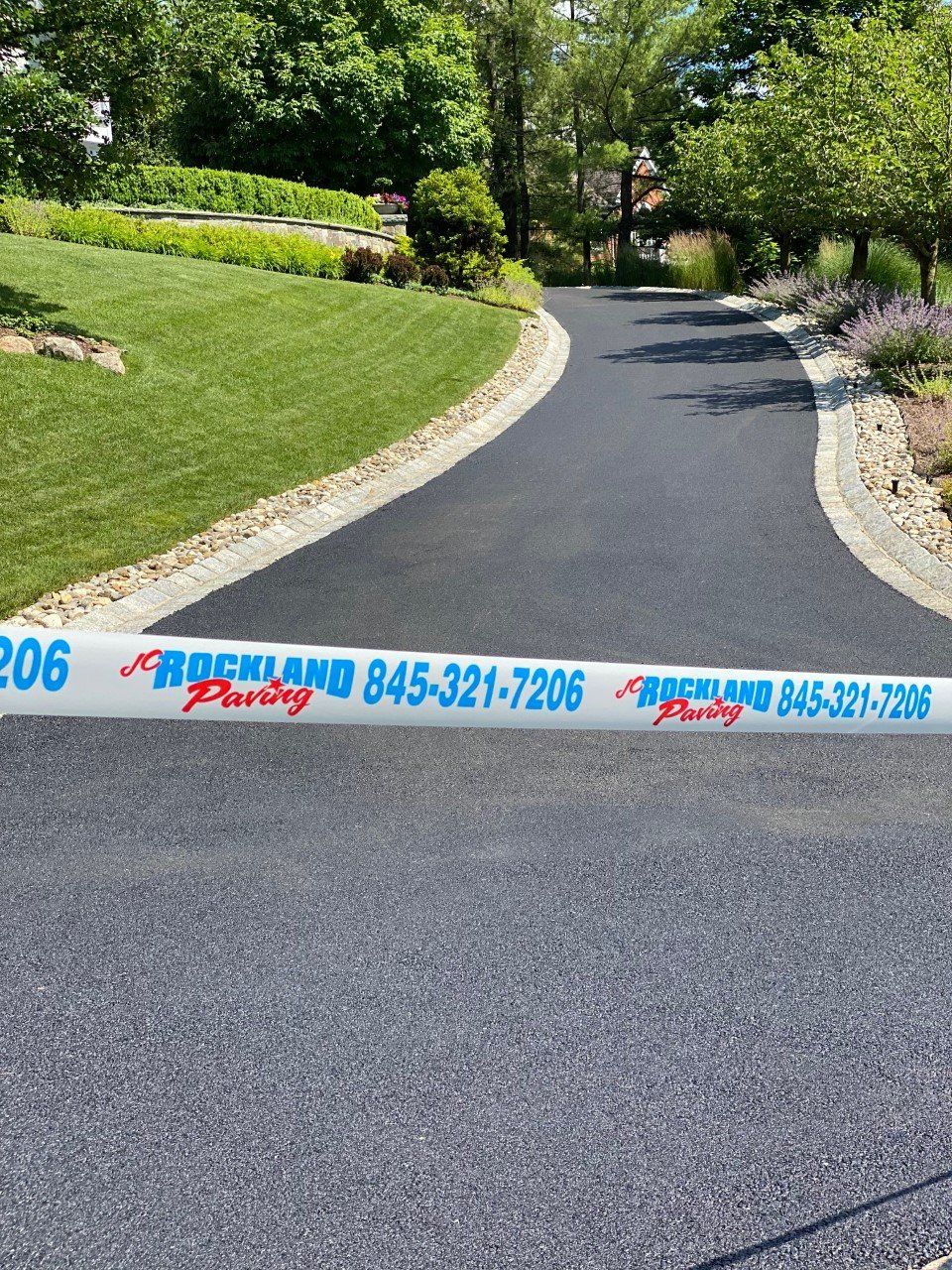 A road with a white tape on it that says rockland paving