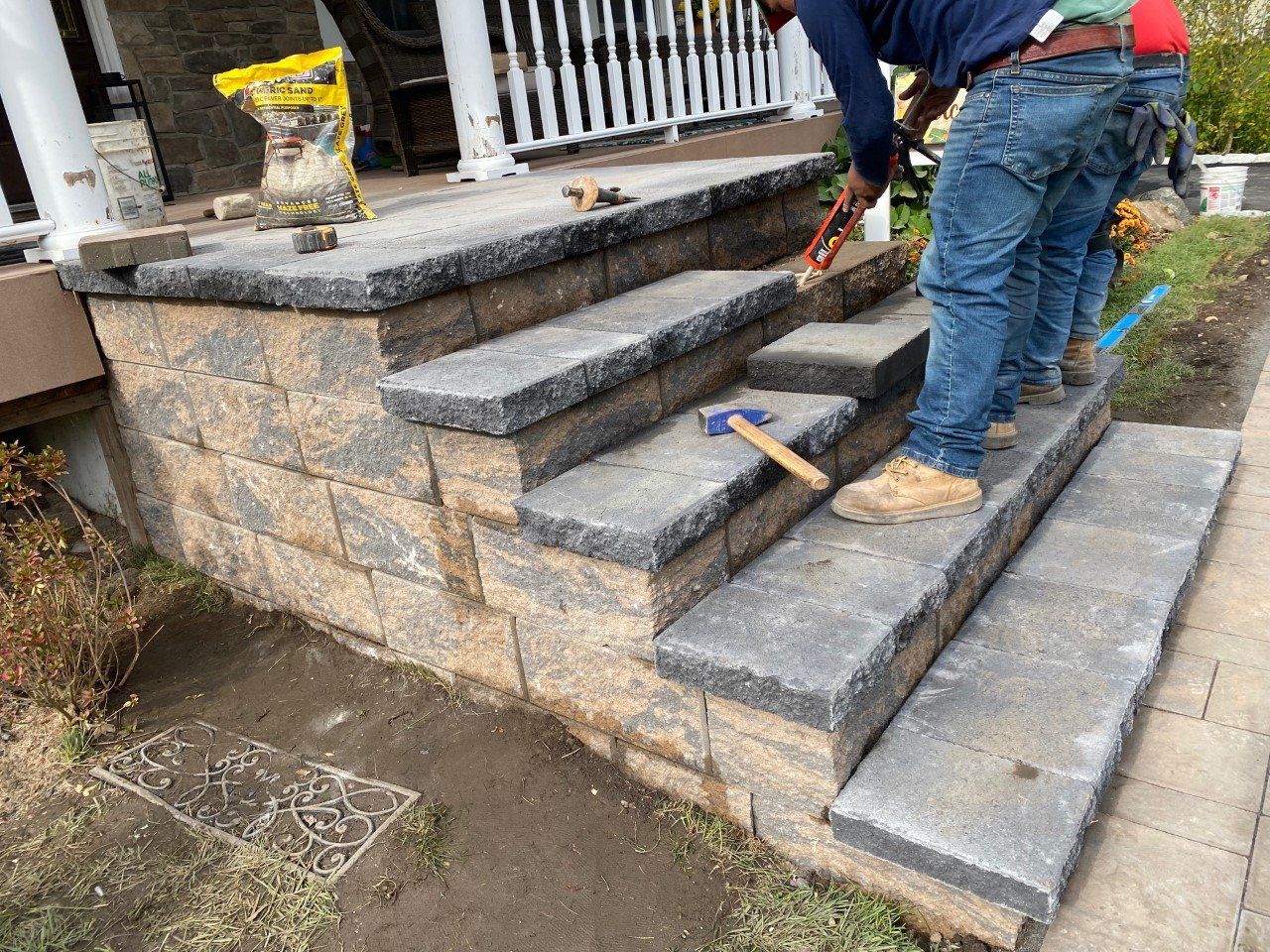 A man is working on a set of stairs in front of a house.