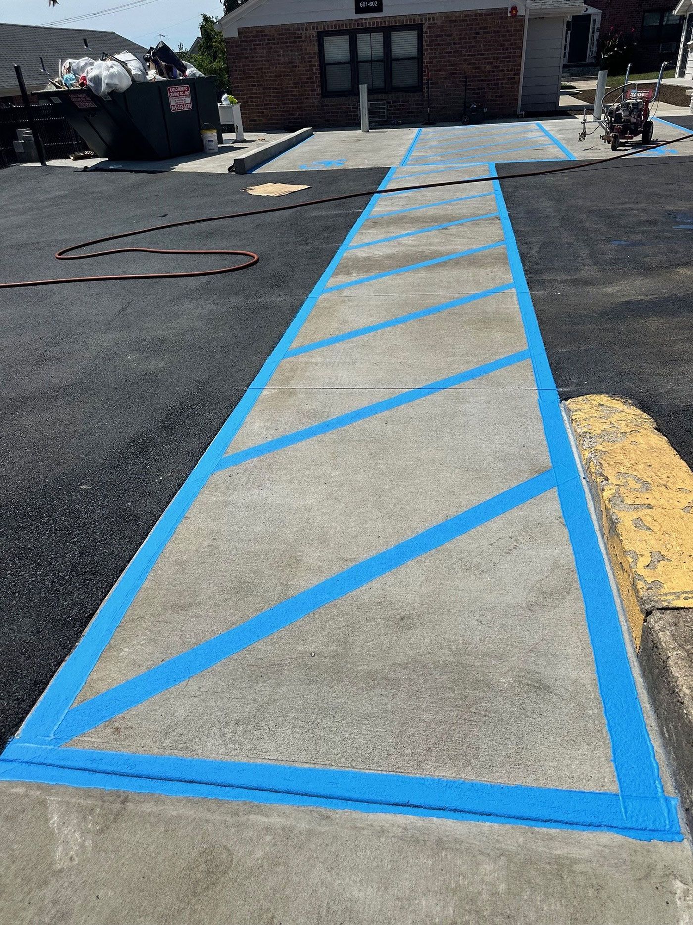 A handicapped parking space is painted blue in a parking lot.