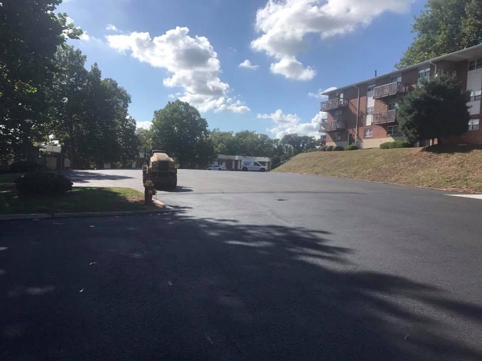 A parking lot with a building in the background on a sunny day
