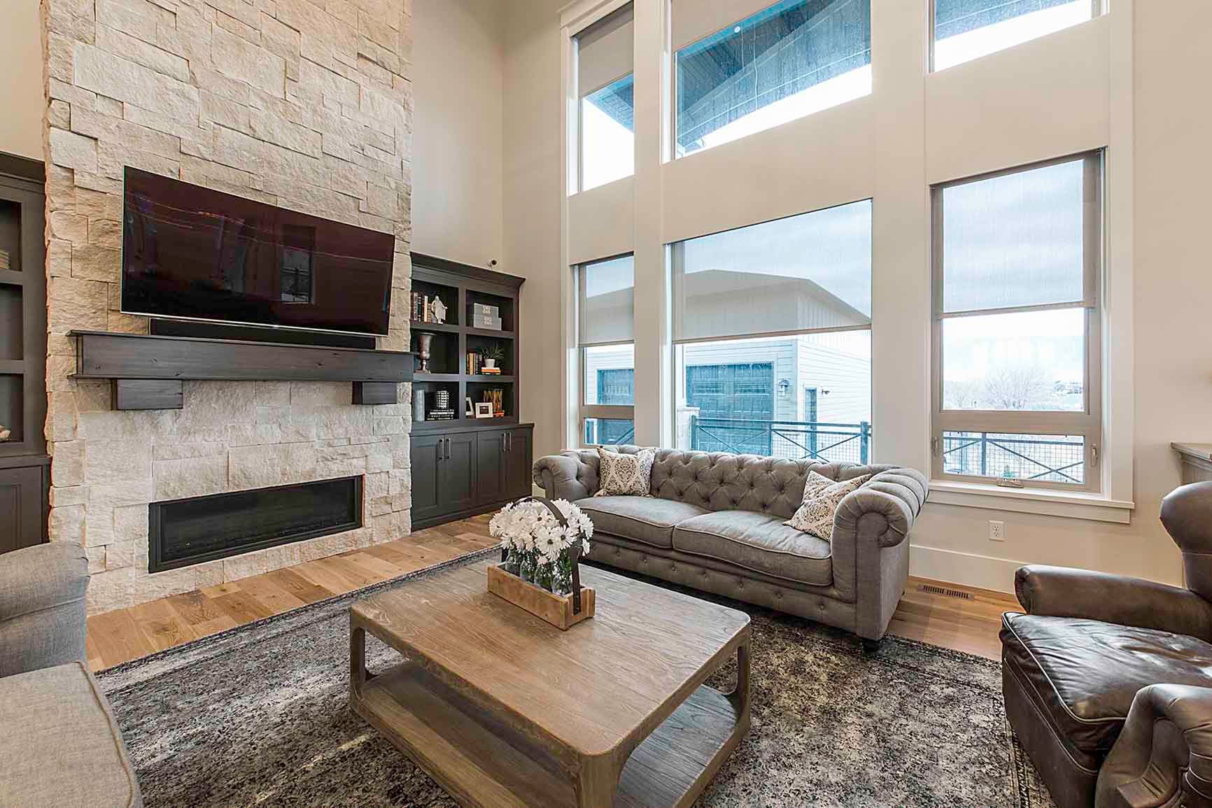 A living room with a couch , chair , coffee table , fireplace and television.