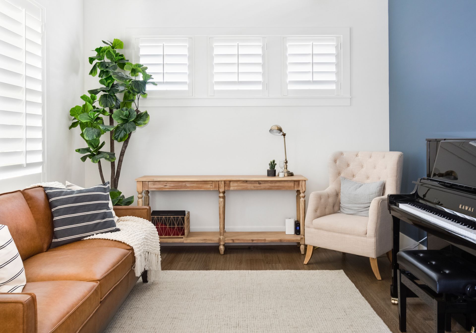 A living room with a couch , chair , and piano.