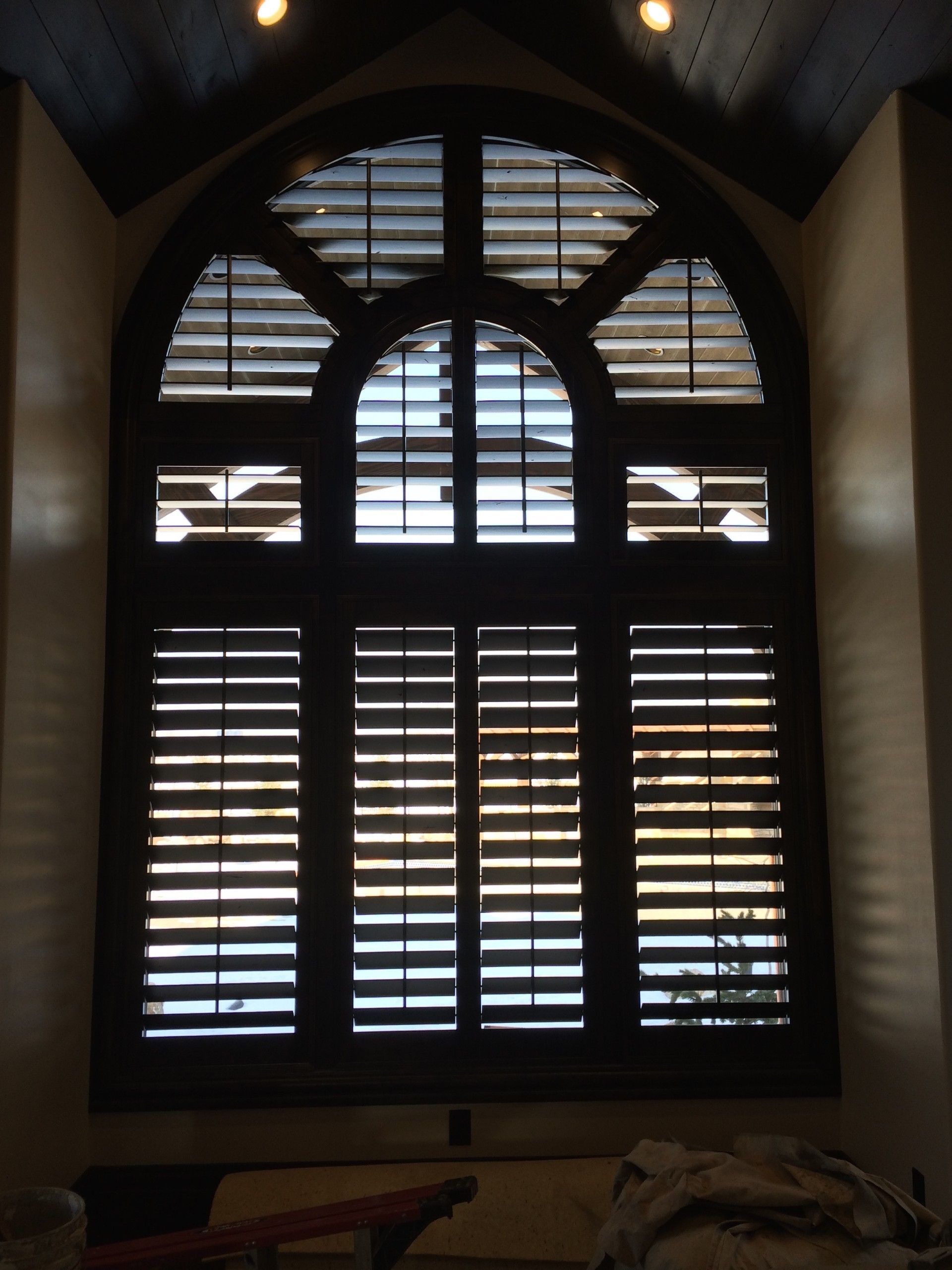 A large arched window with shutters on it