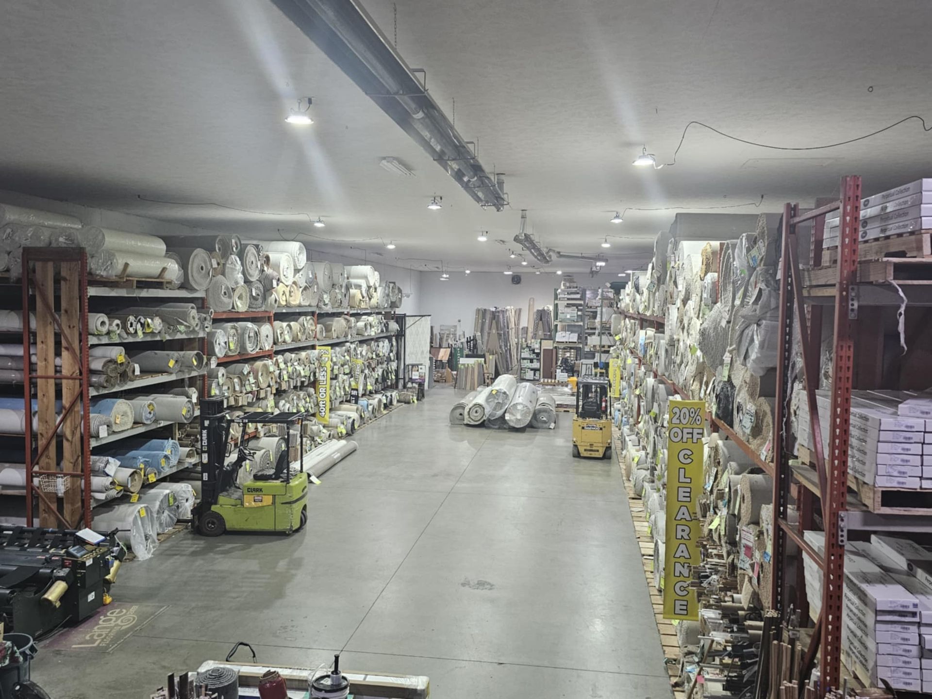 A large warehouse filled with lots of shelves and trucks.