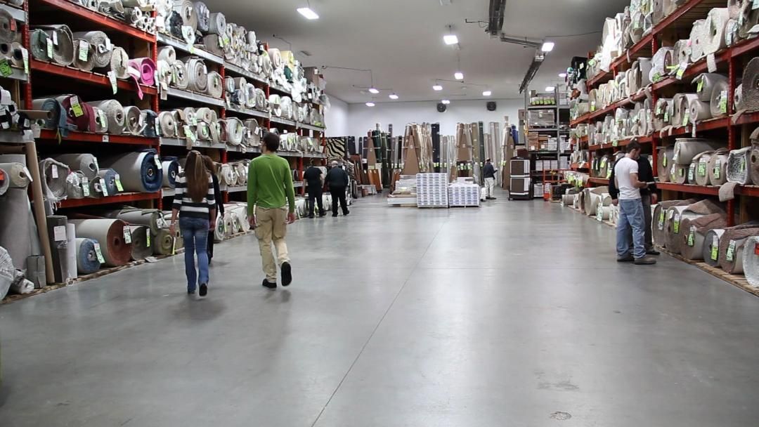 A group of people are walking through a large warehouse.