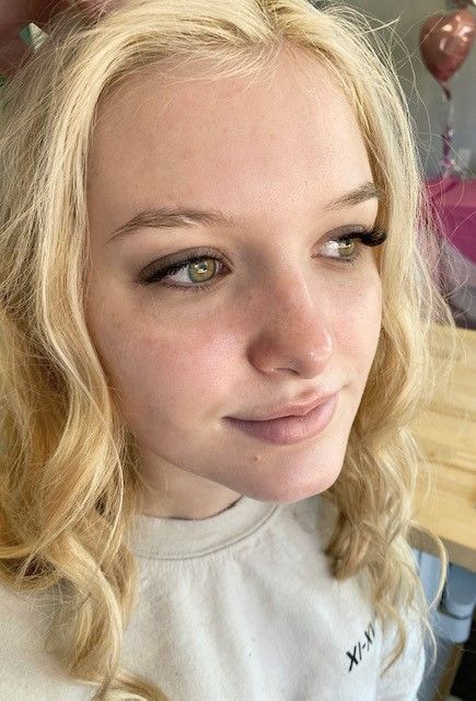photo of a blonde girl showing her newly installed lashes