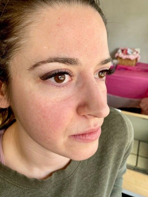 photo of a girl in olive shirt showing her newly installed lashes