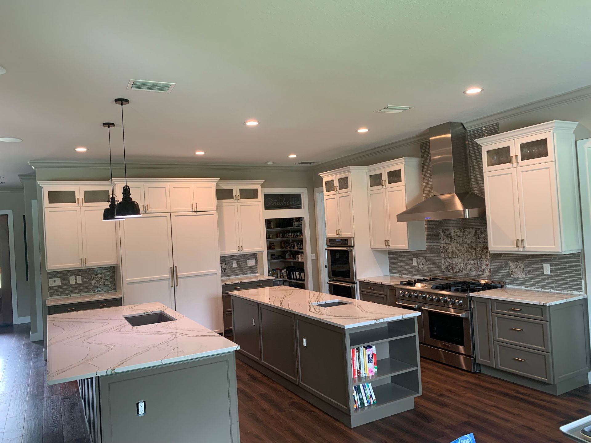 Modern kitchen with white cabinets, gray island, stainless appliances, and recessed lighting