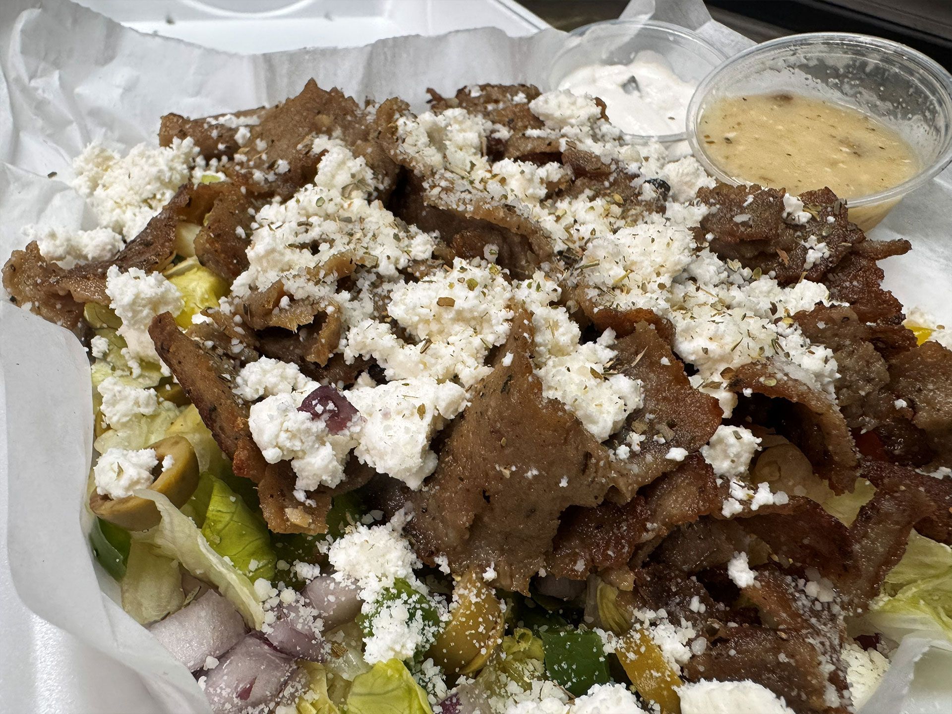 Gyro salad with meat, feta, and dressing.