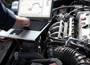 Professional car mechanic using computer on auto diagnostic