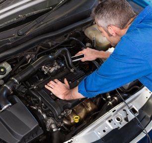 Mechanic working under the hood at the repair garage