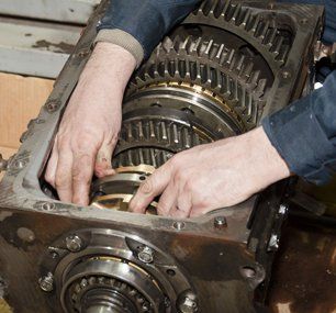 Professional car mechanic working on transmission gearbox