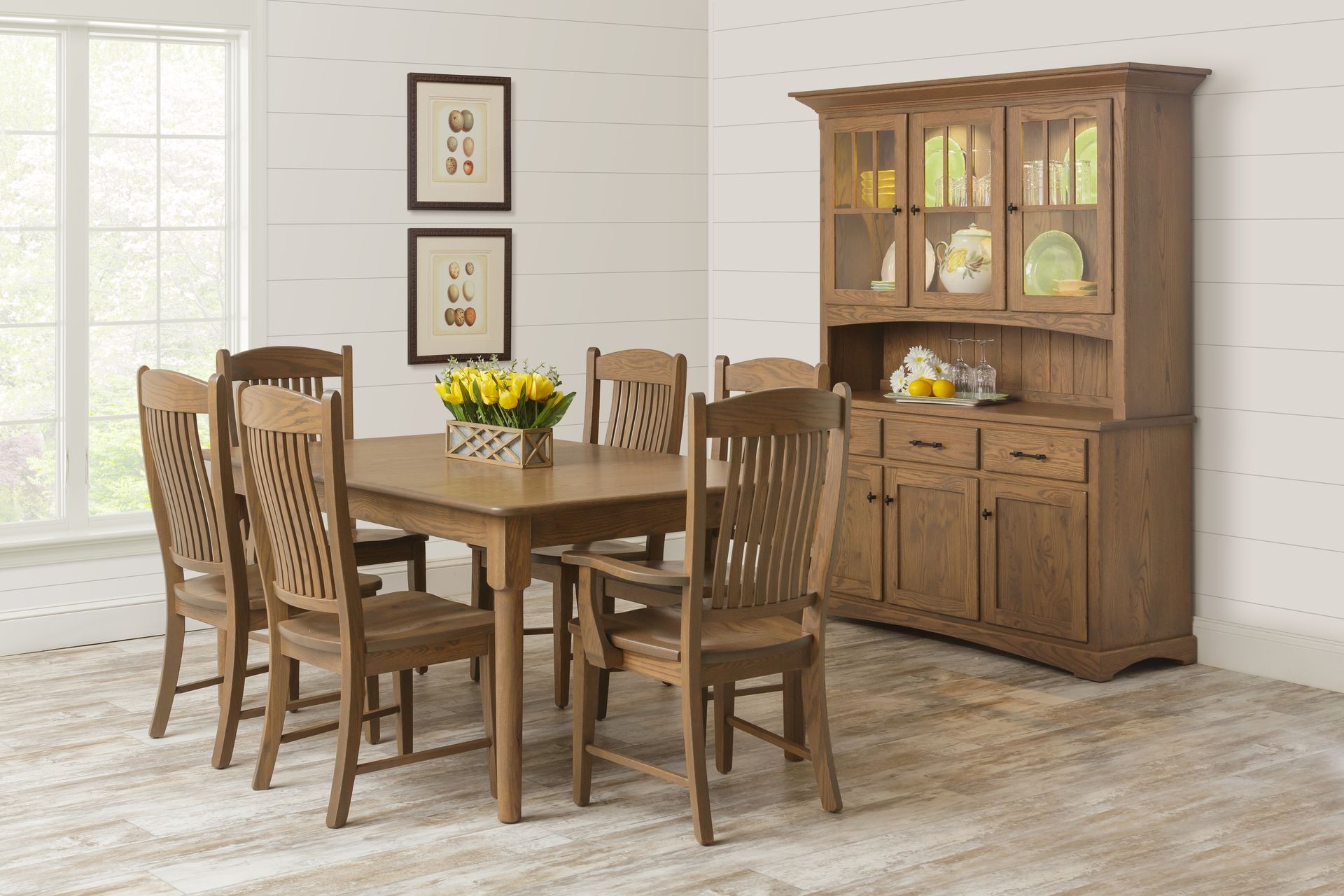 A dining room with a table and chairs and a hutch.