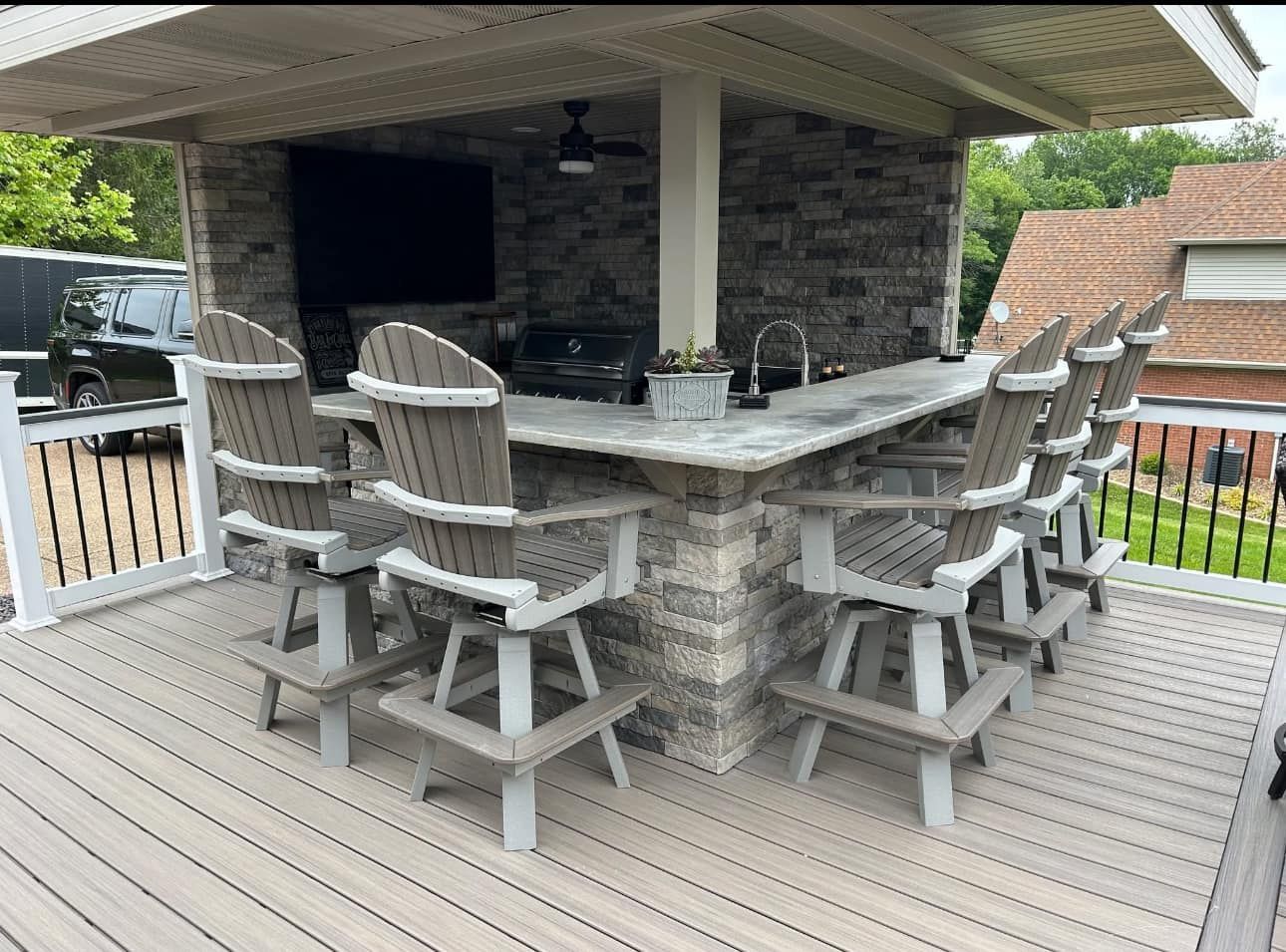 A deck with a bar and chairs on it