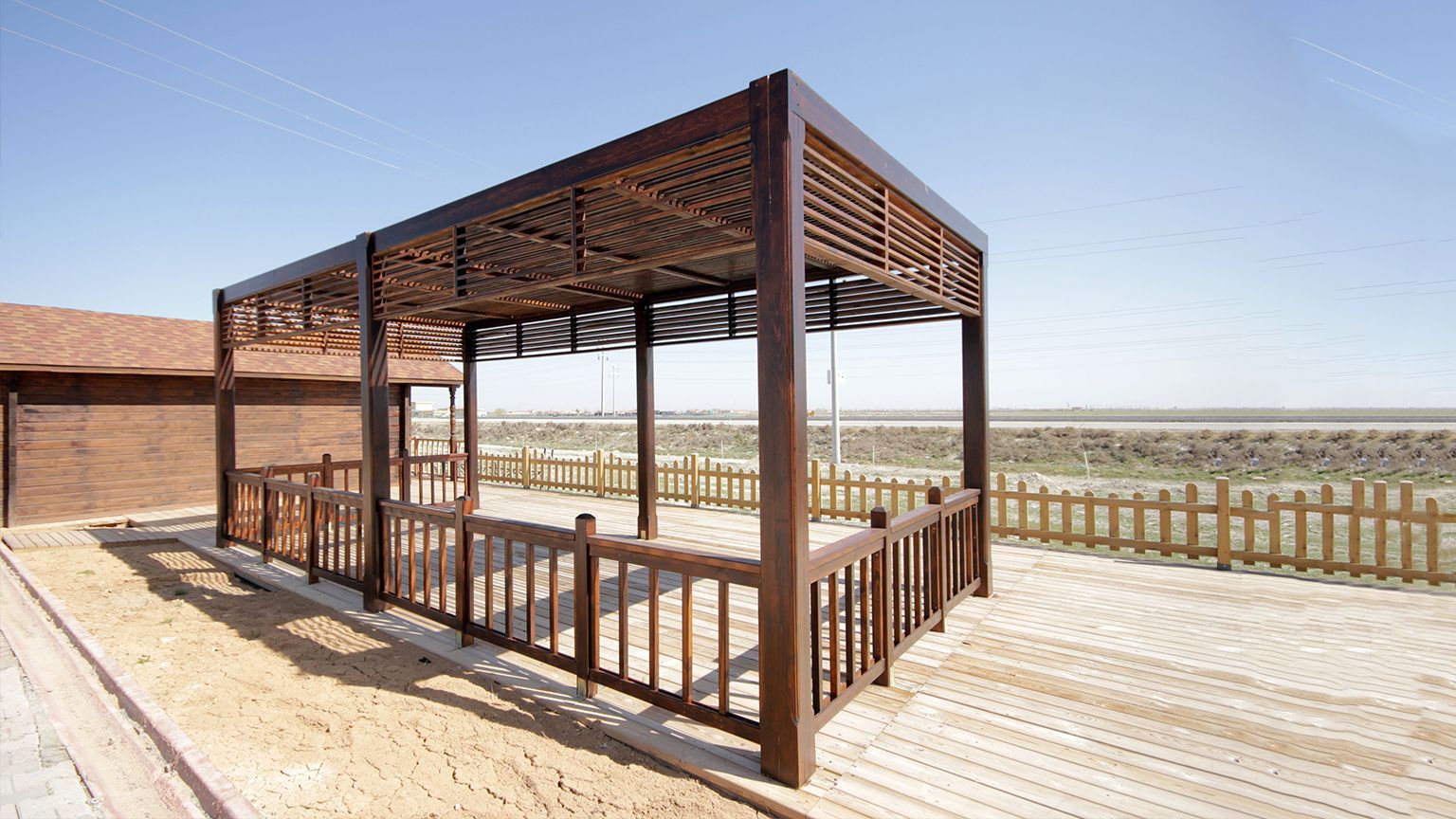 A wooden gazebo with a wooden fence around it