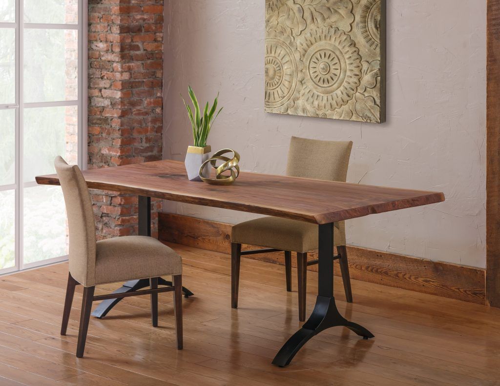 A dining room with a table and chairs and a painting on the wall.