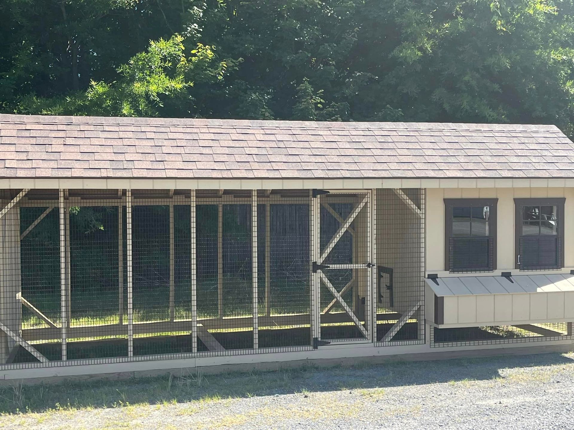 A chicken coop with a roof that has shingles on it