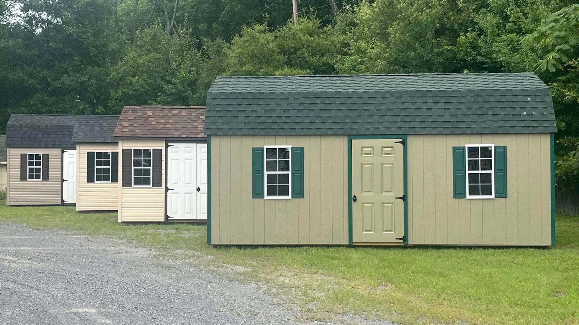 A row of sheds are lined up in a grassy area