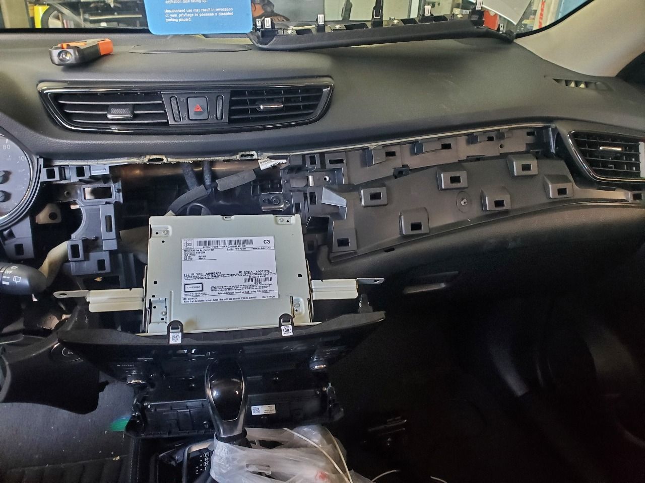 Car dashboard removed, exposing the center console and wiring during repair