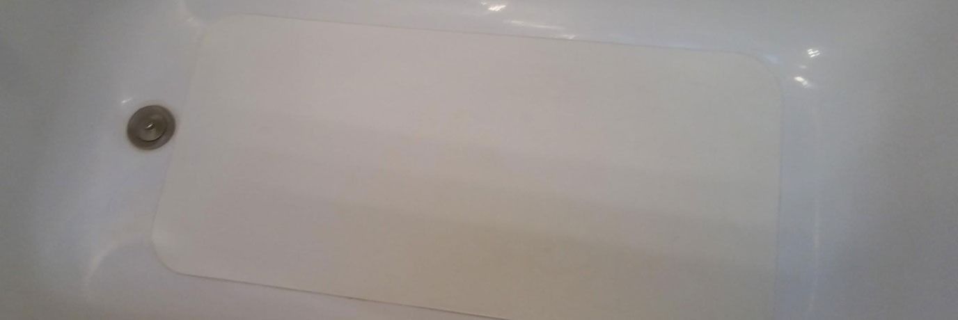 Empty white bathtub with a drain visible near the corner.