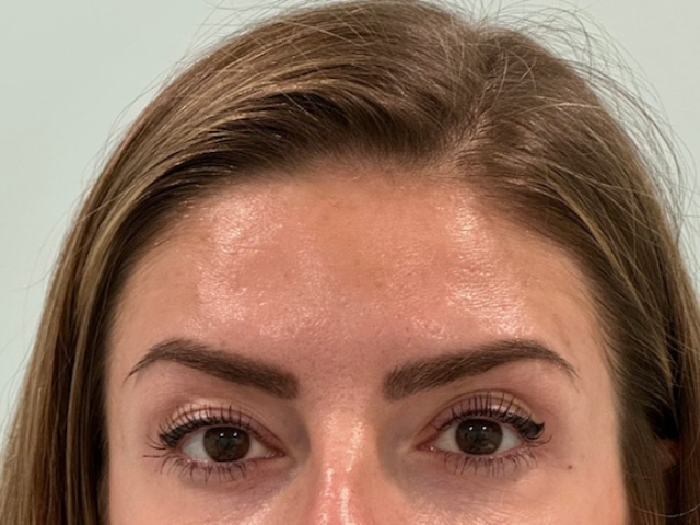 Woman's face close-up, brown eyes, light skin, arched eyebrows, subtle eyeliner.