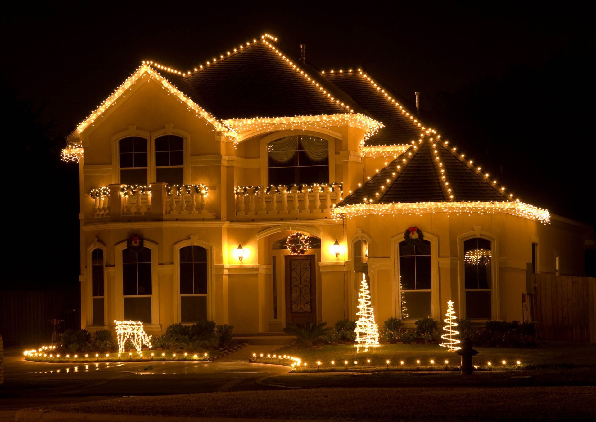 House decorated with yellow Christmas lights at night.
