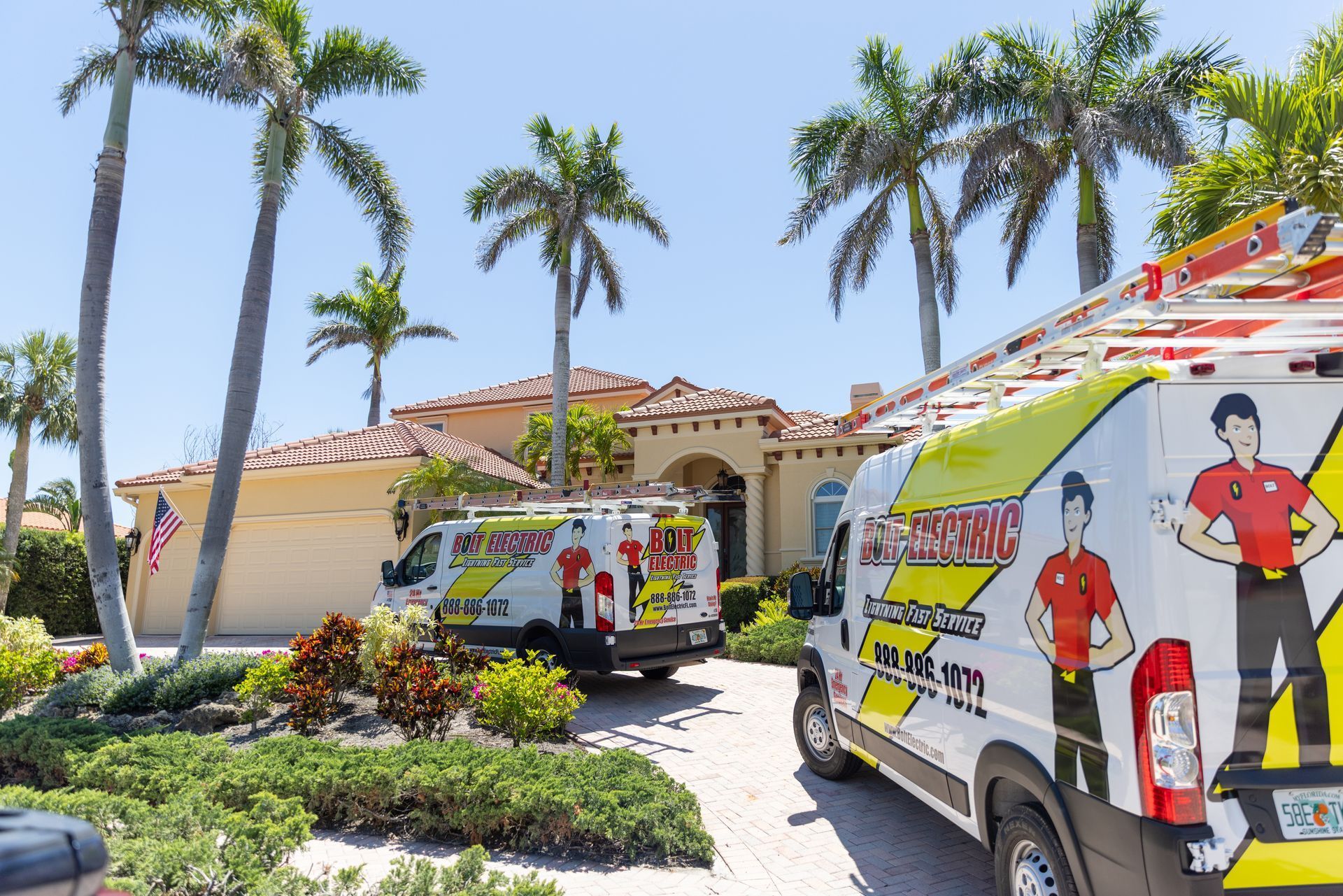 Two service vans are parked in front of a house.