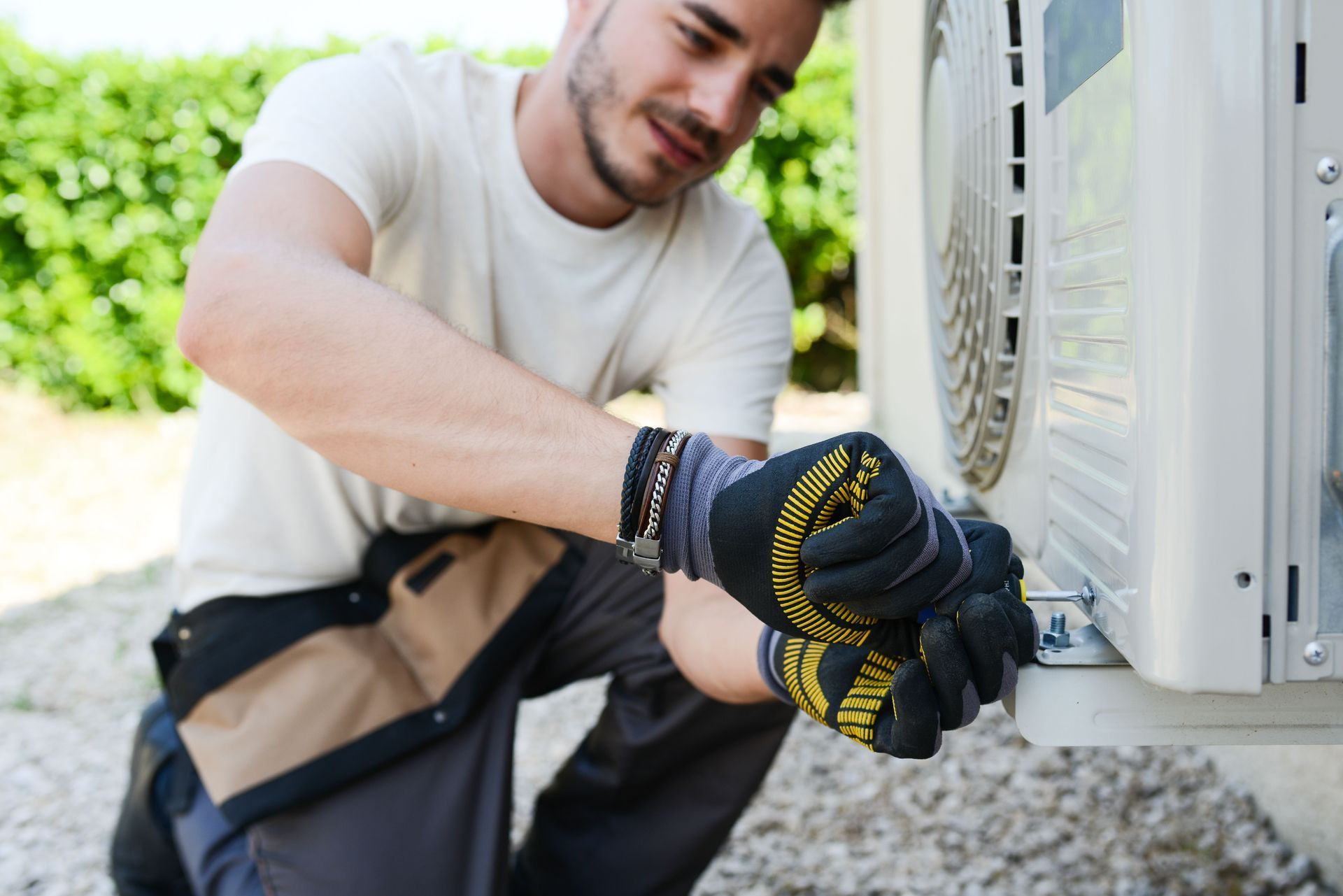 Man in work clothes, installing an air conditioning unit.
