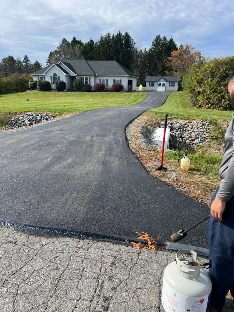 a man is standing next to a propane tank on the side of a road .