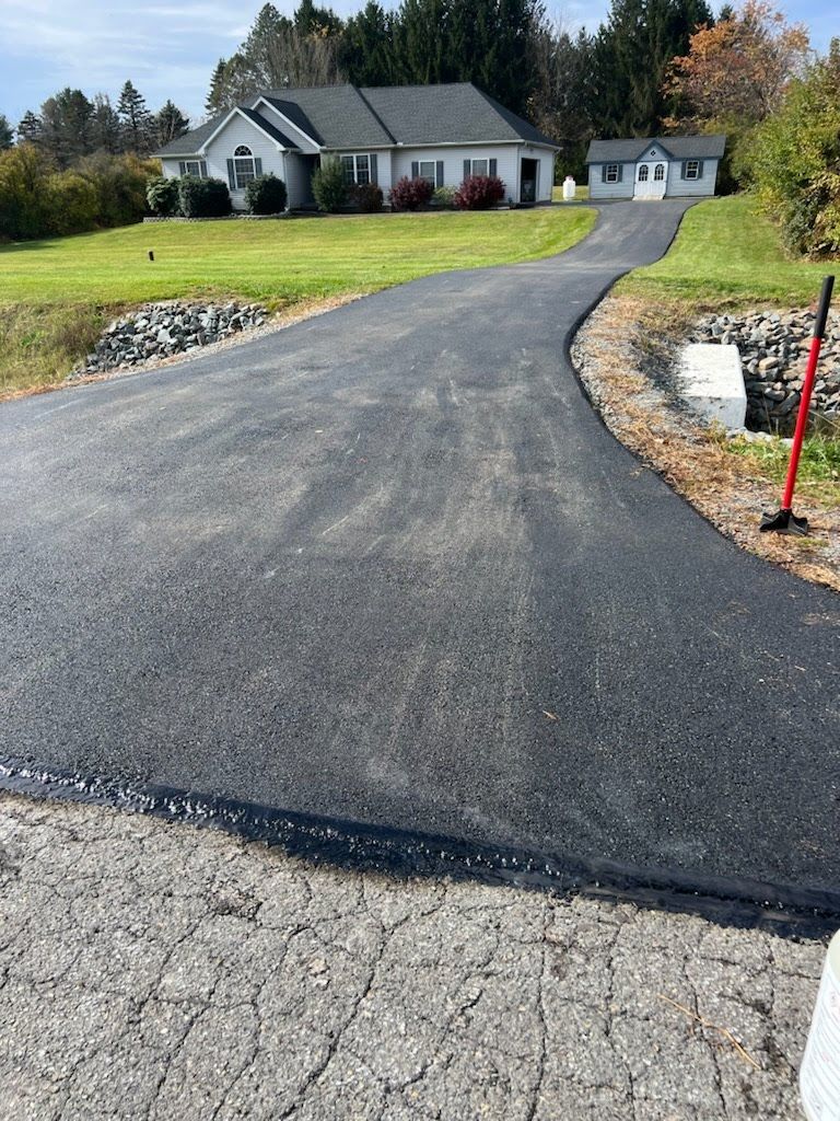 a newly paved driveway leading to a house .