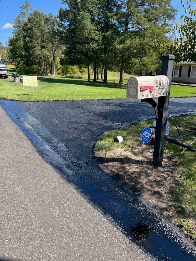 a mailbox is sitting on the side of a road next to a driveway .