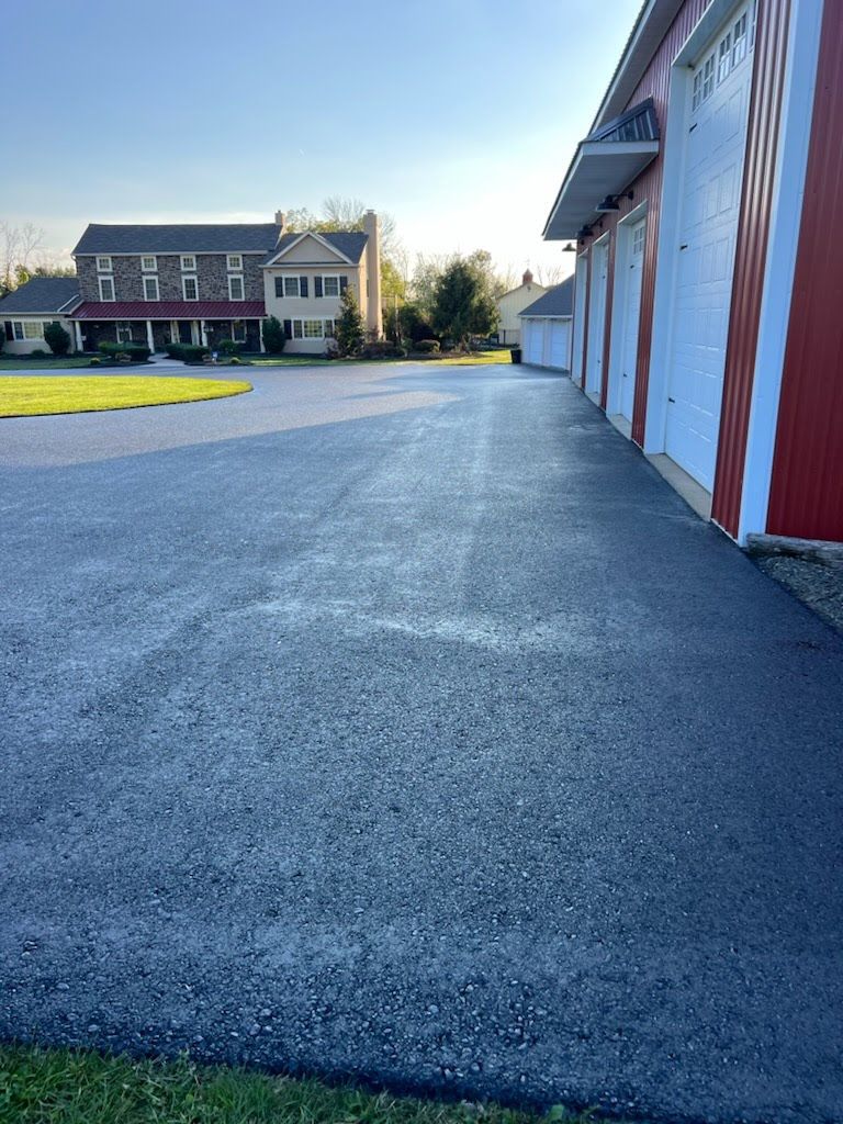 a driveway with a garage and a house in the background .