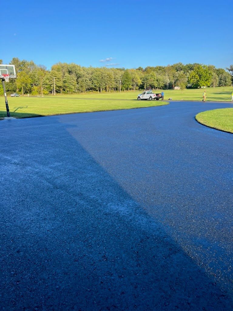 a basketball hoop is in the middle of a driveway .
