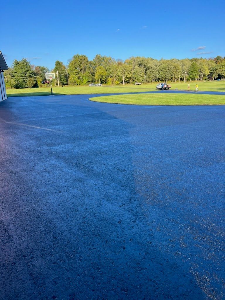 a large empty parking lot with a grassy field in the background .