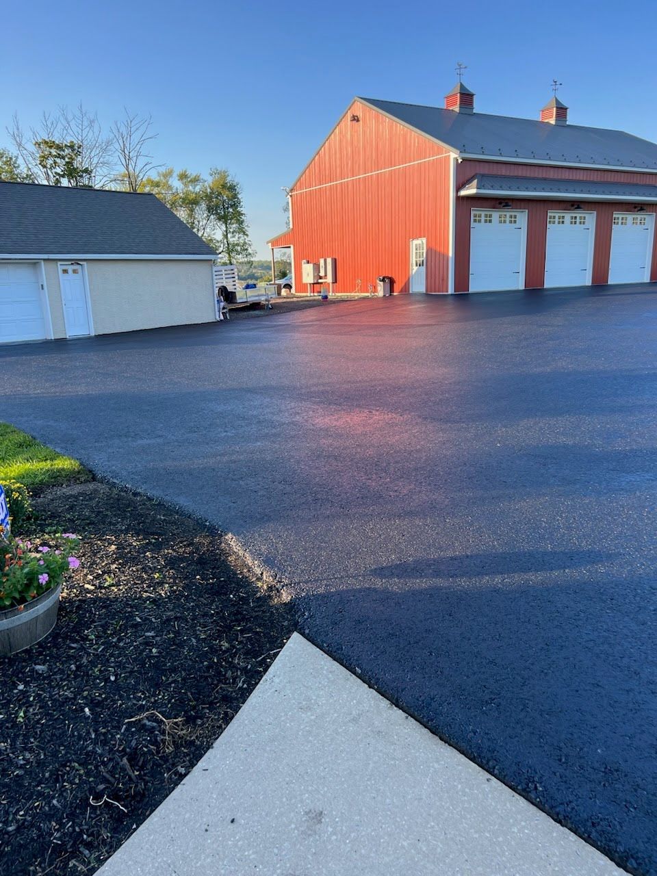 a parking lot with a red barn in the background