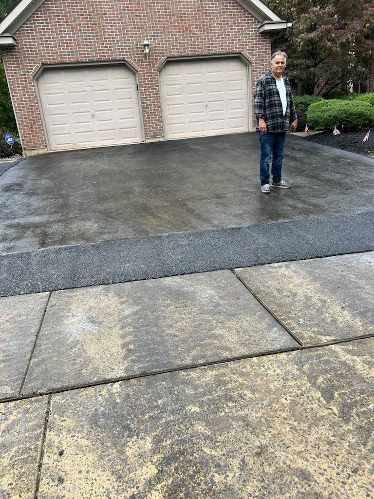a man is standing in a driveway in front of a brick garage .