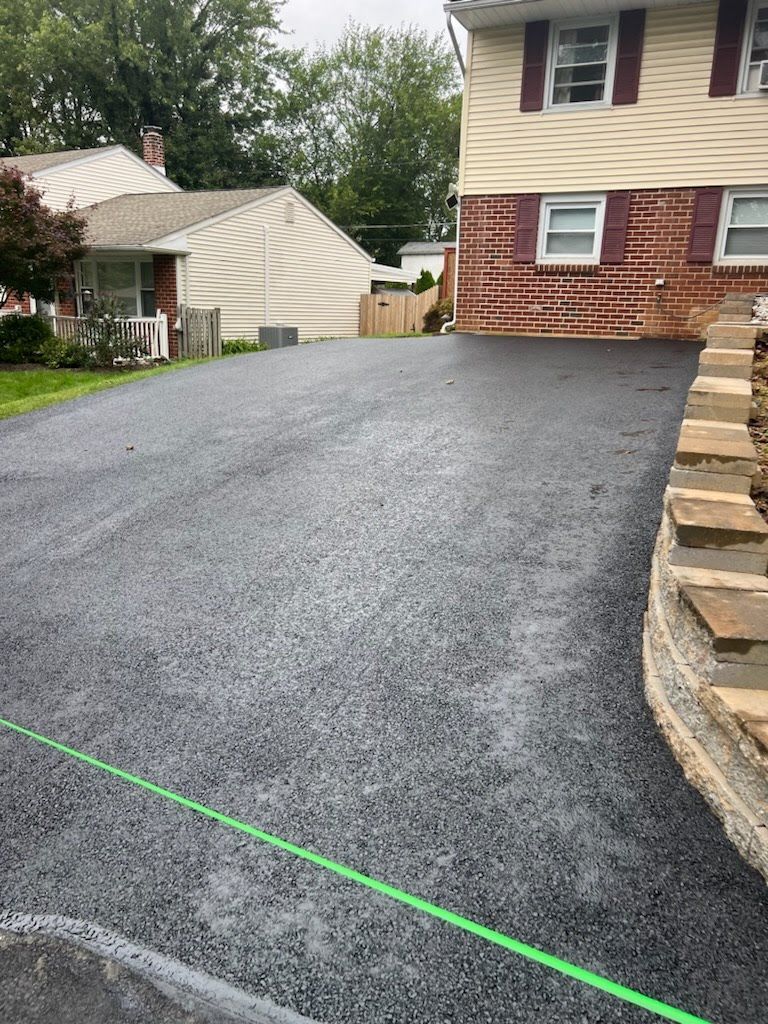 there is a green line on the road in front of a house .