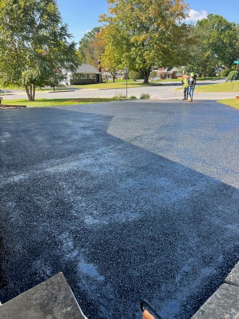a person is laying asphalt in a driveway .