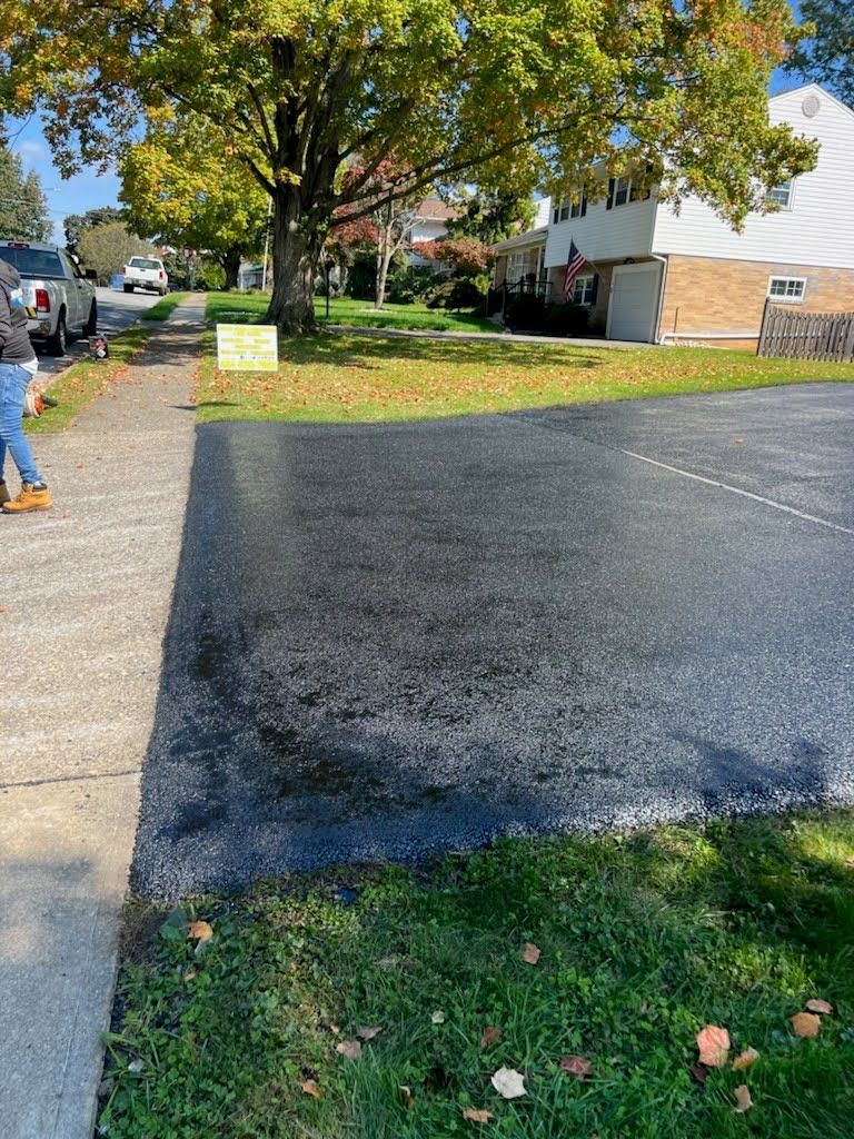 a person is walking down a sidewalk next to a parking lot .