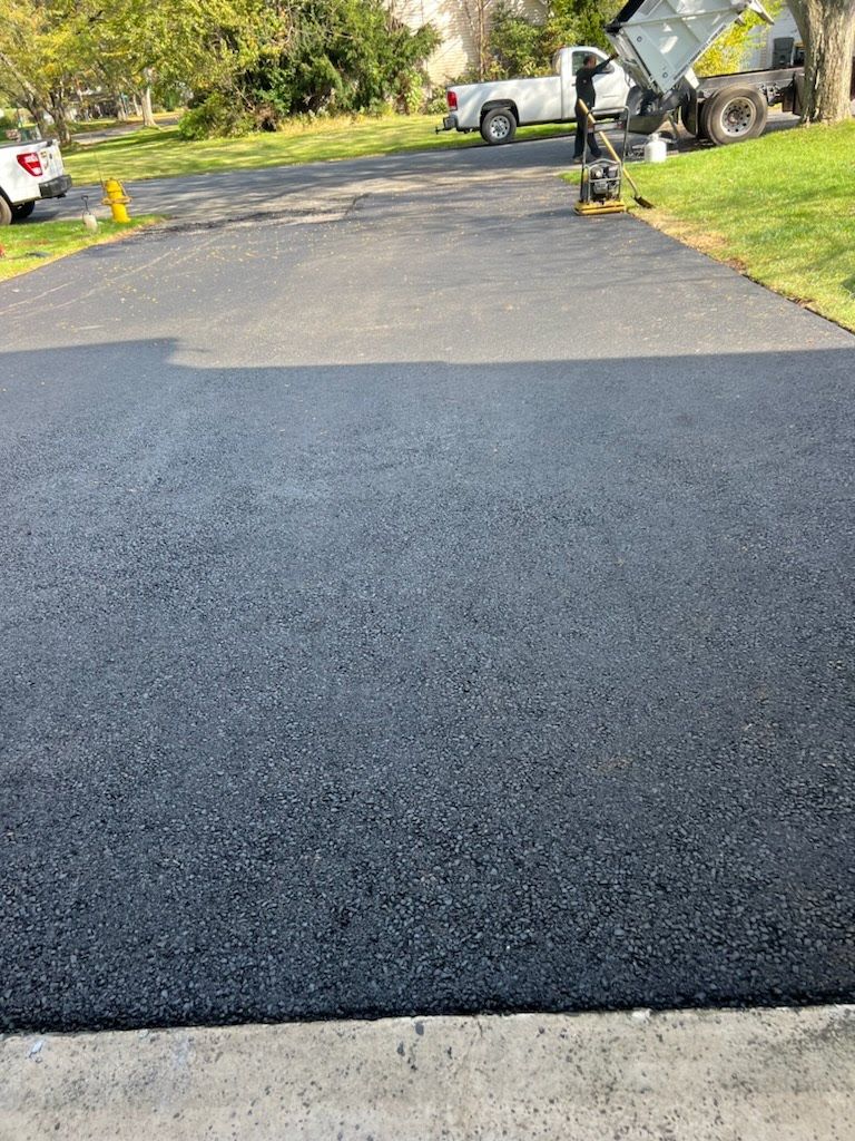a newly paved driveway with a truck parked on the side of it .