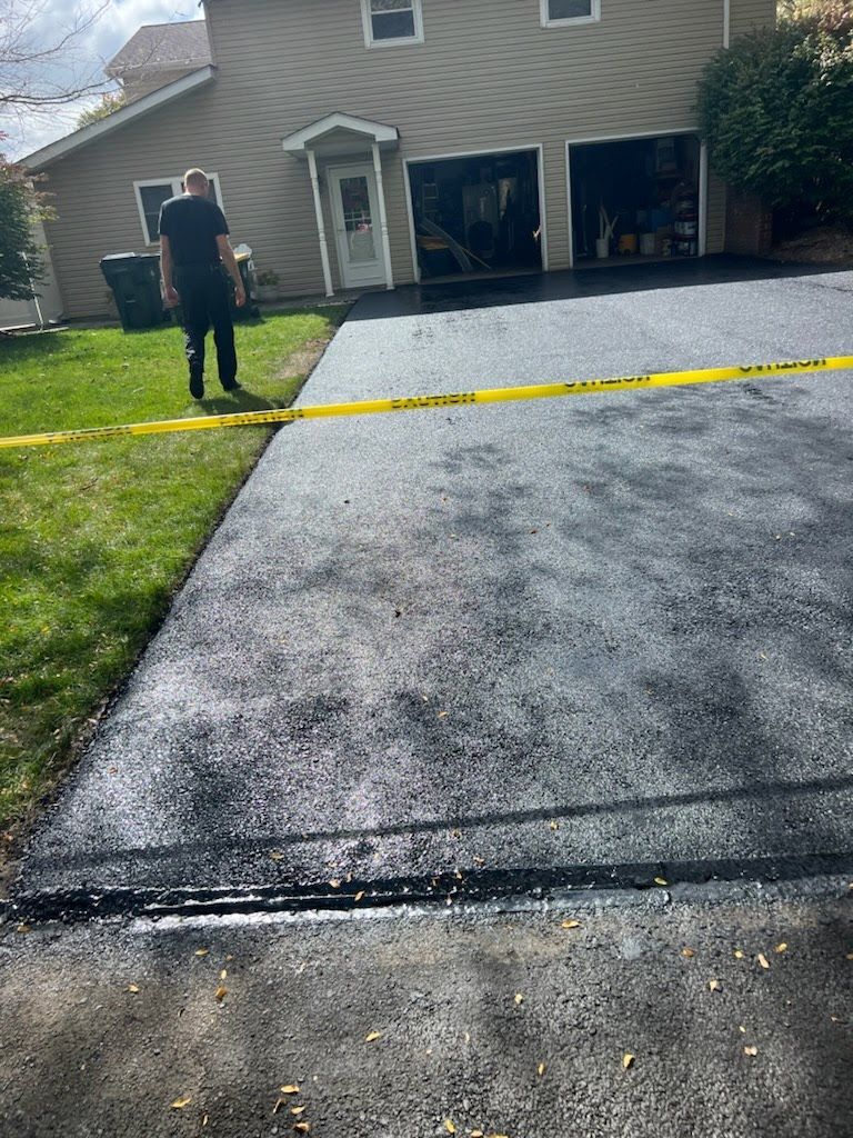 a man is standing in a driveway next to a house .