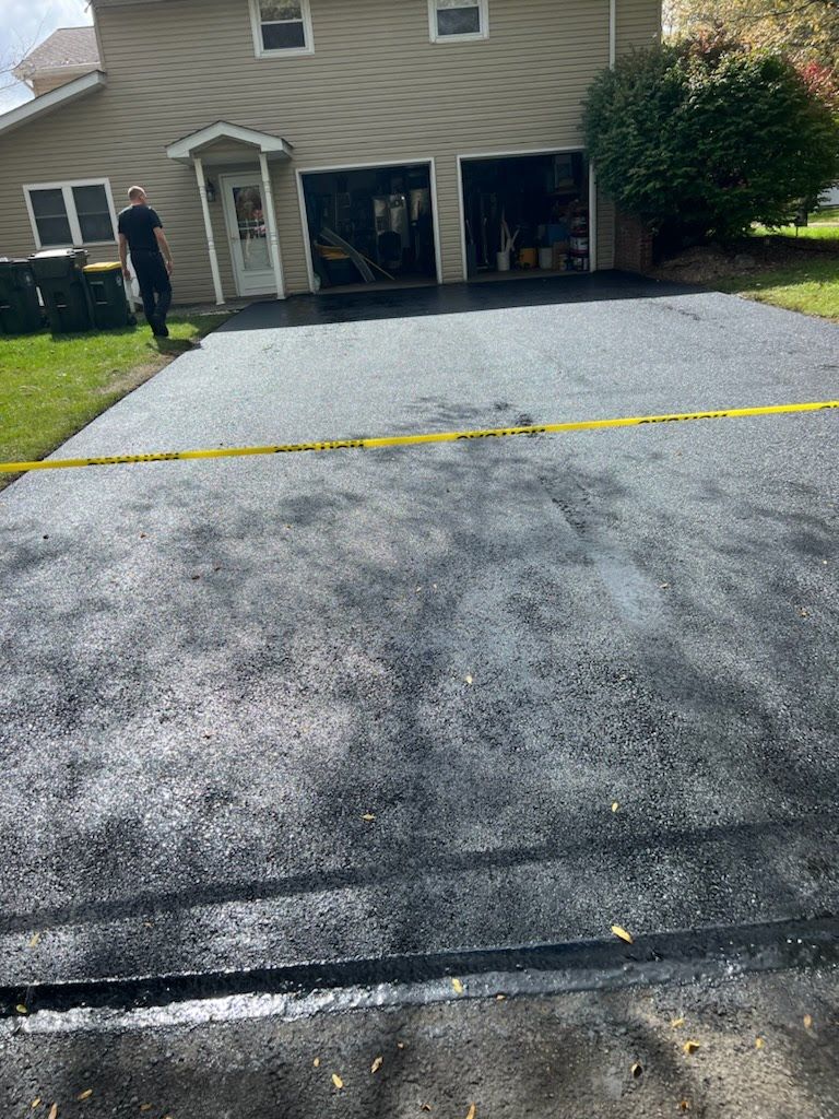 a man is standing in a driveway next to a house .