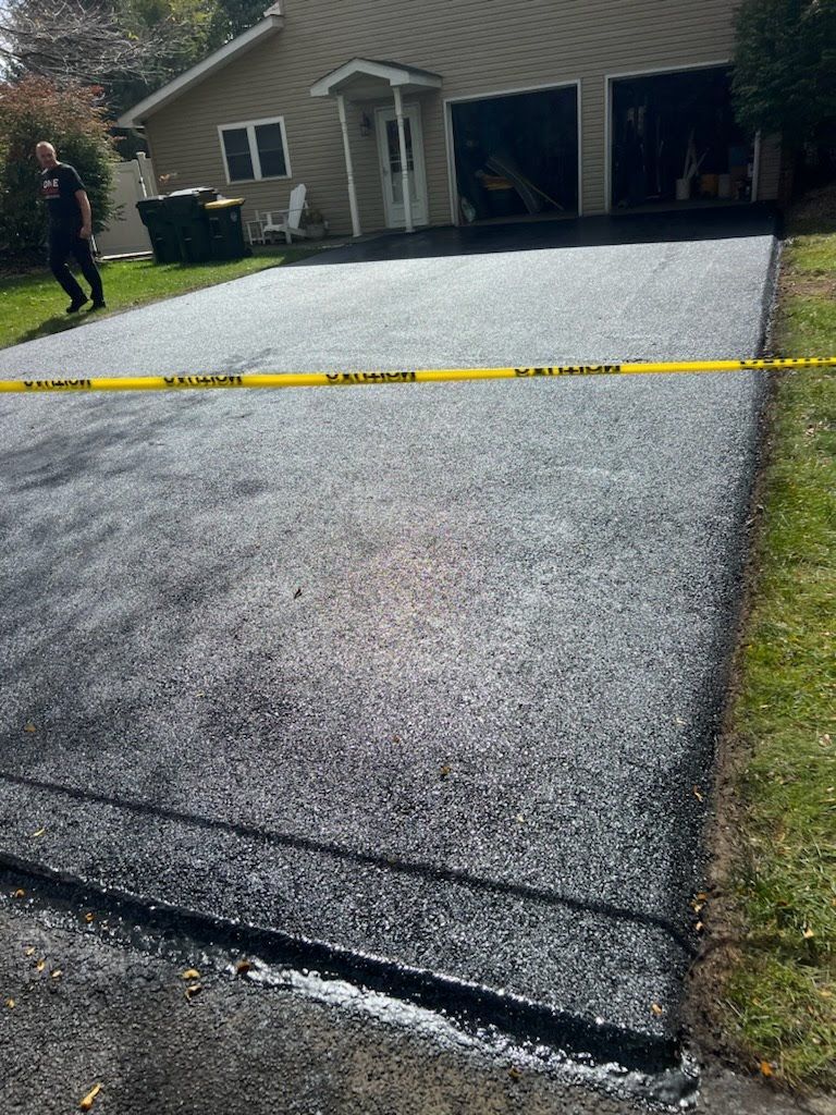 a man is walking down a newly paved driveway in front of a house .