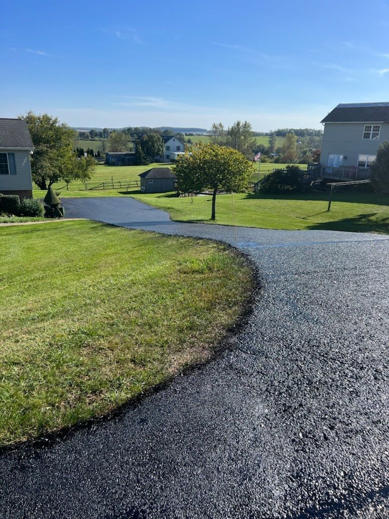 a curved driveway leading to a house in a residential area .